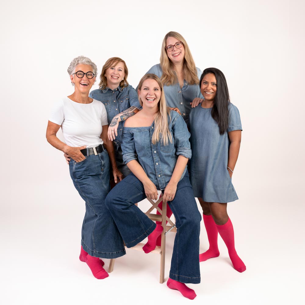 Gruppenfoto von fünf Frauen, die pinke Kompressionsstrümpfe von xunt tragen